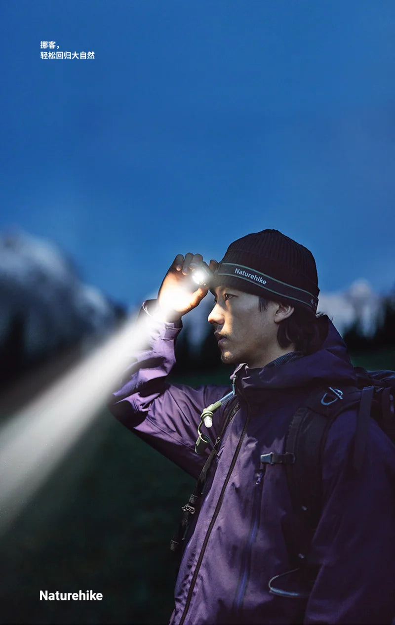 Hiker wearing a headlamp outdoors at dusk