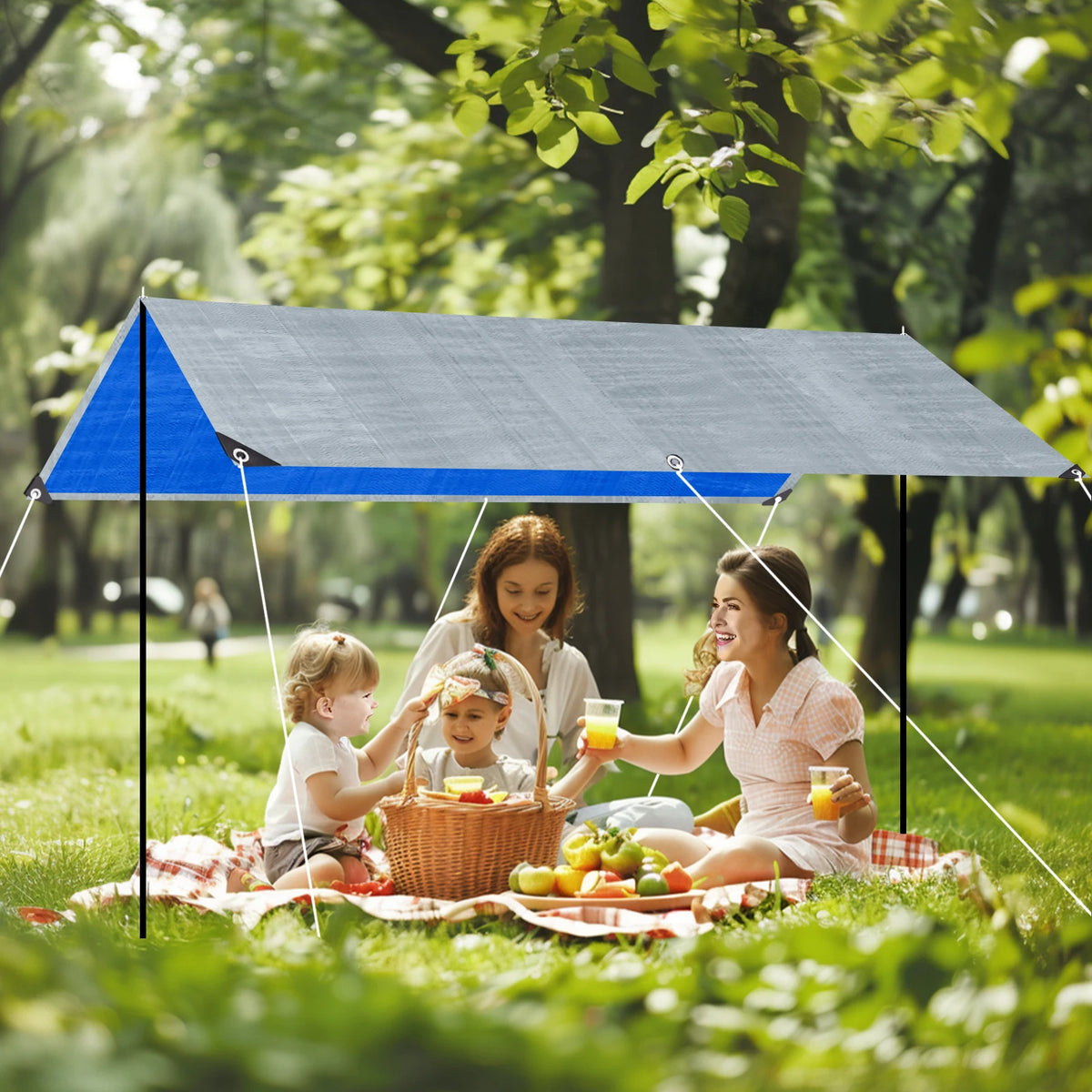 Family picnicking under a blue and silver tarp shelter