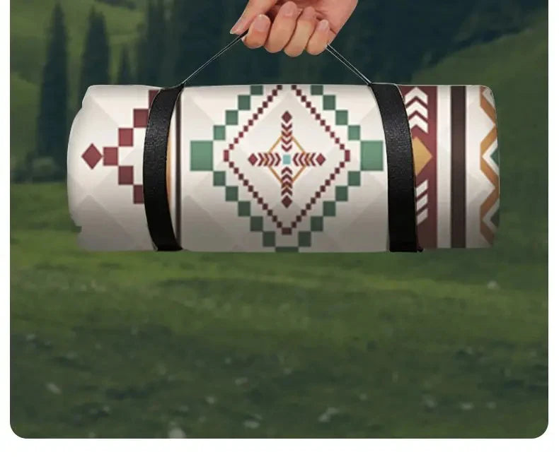 Rolled picnic blanket carried by its strap