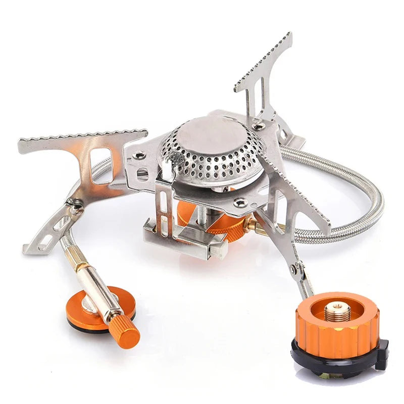 Folding camping gas stove with legs open and canister adapter attached