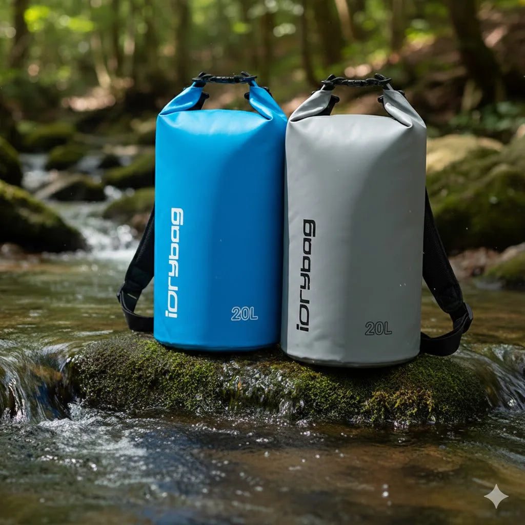 Blue and gray roll-top dry bags on a mossy rock beside a stream